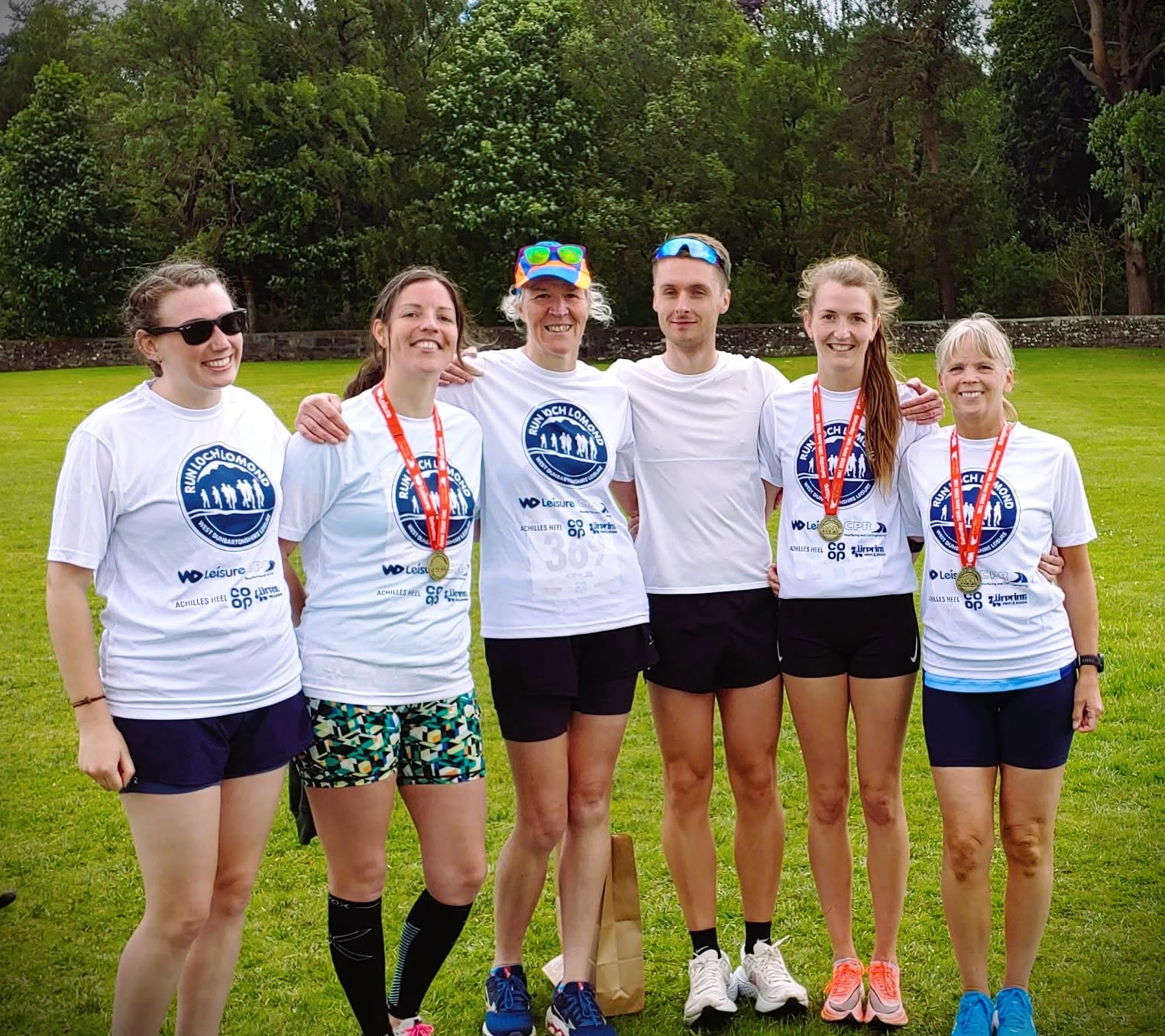 Six Lomond runners smiling together after an event